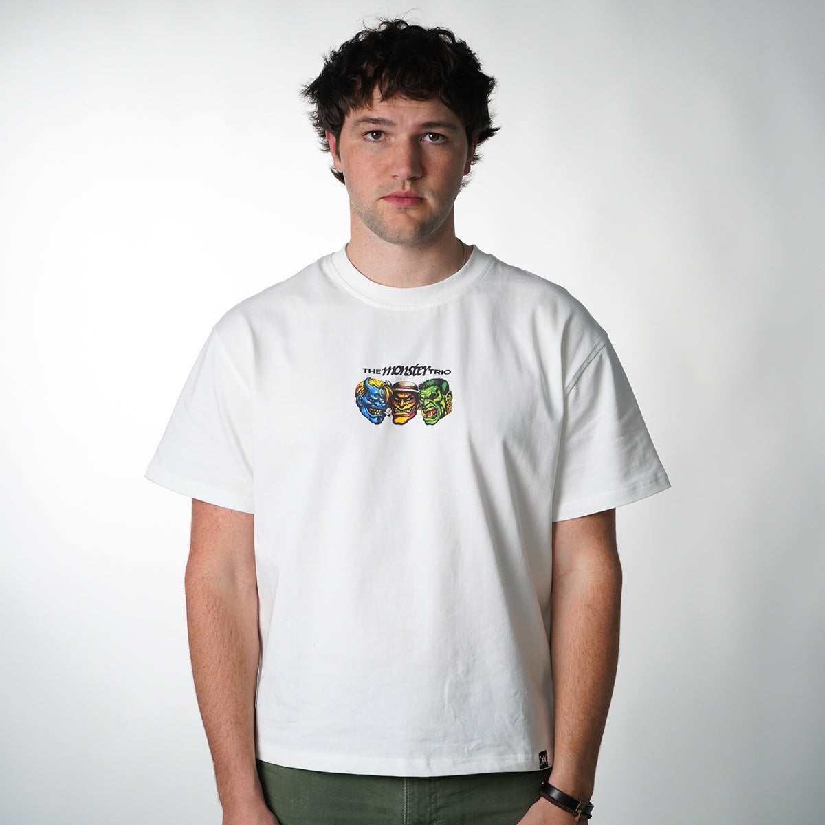 Person wearing a white t-shirt with colorful graphic design on a plain background