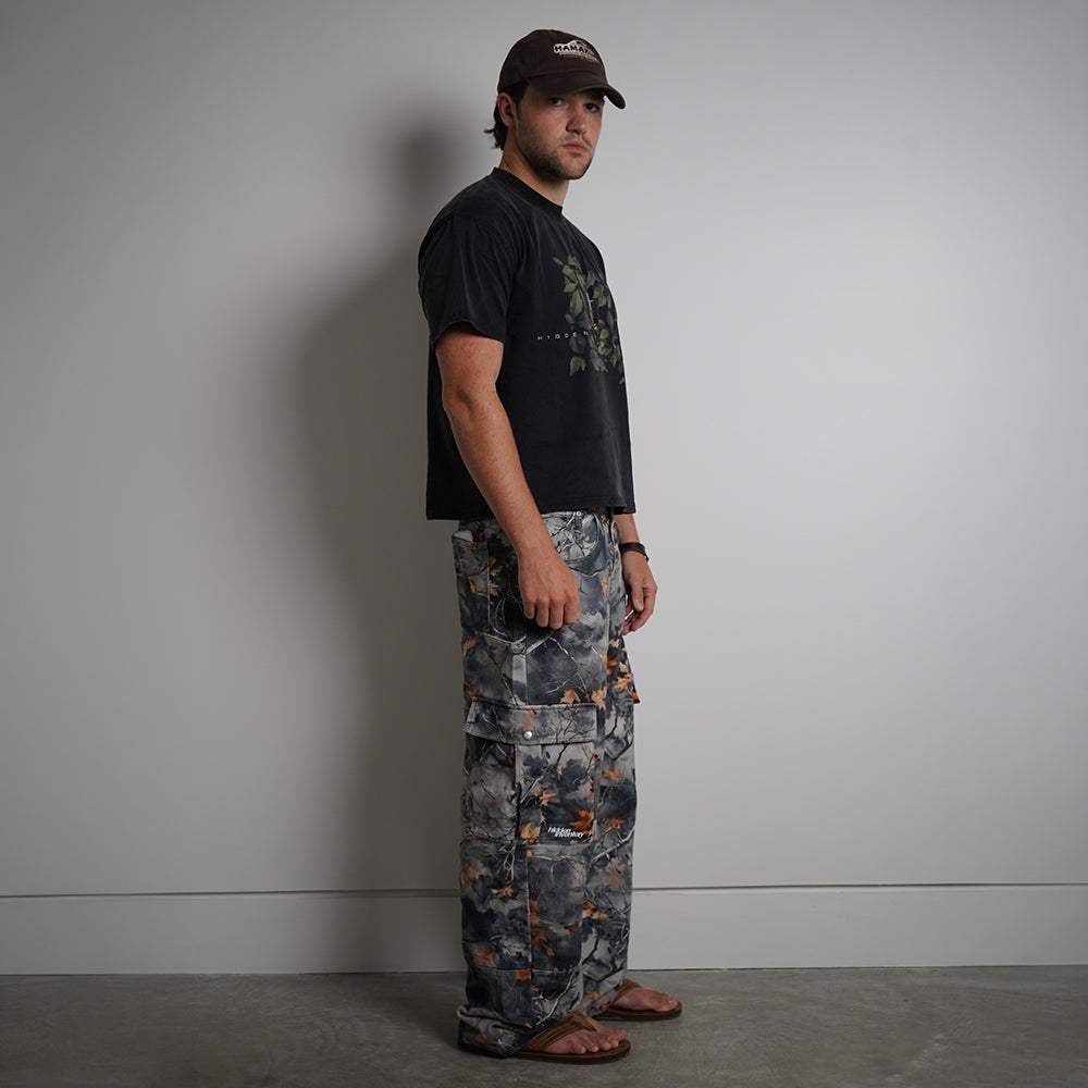 Hidden in the Leaves Tee in charcoal black with anime graphic print, side view on model