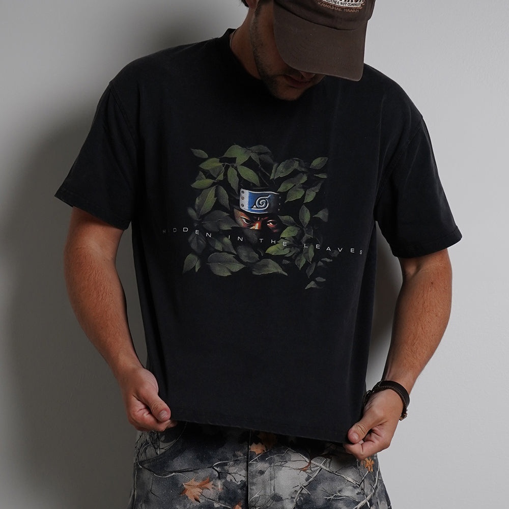 Black Hidden in the Leaves Tee featuring ninja character graphic with green foliage, front view