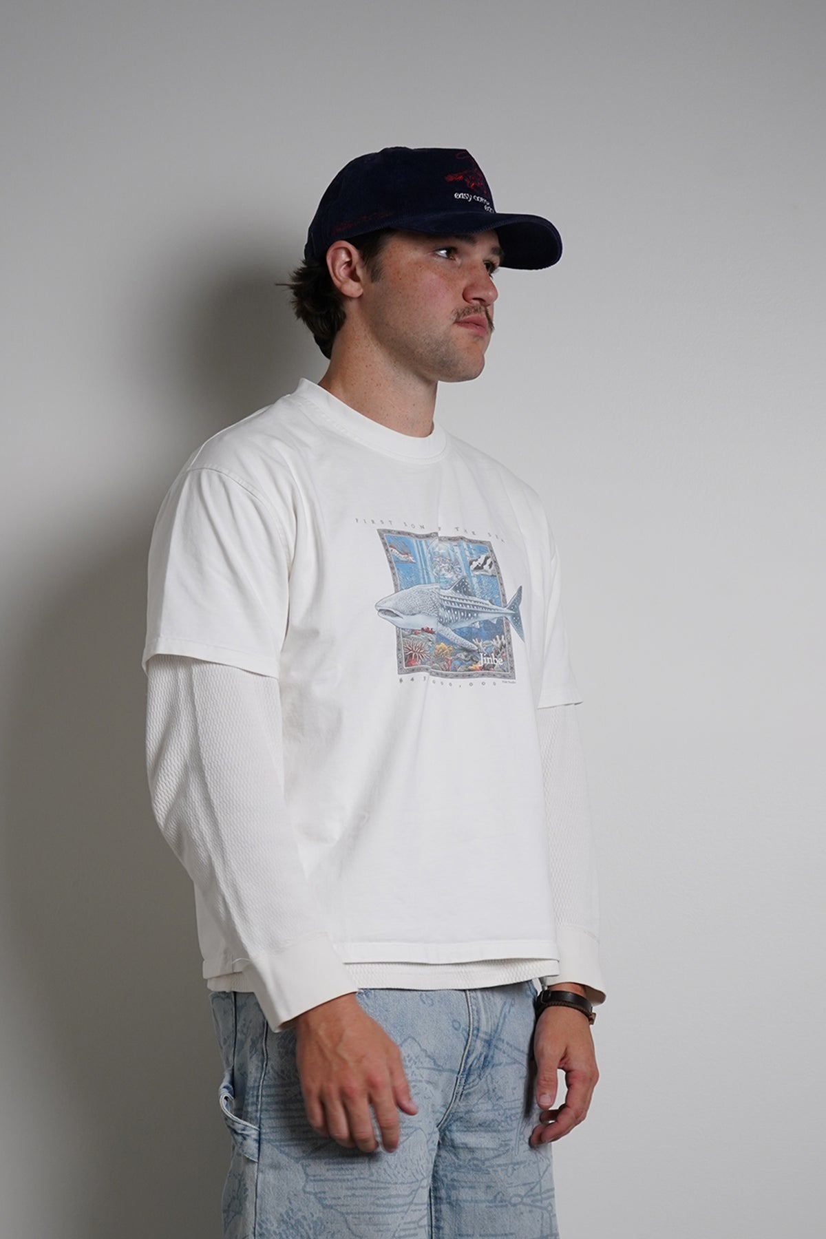 White First Son of The Sea Tee with whale shark graphic, full-length front view on model in light blue jeans