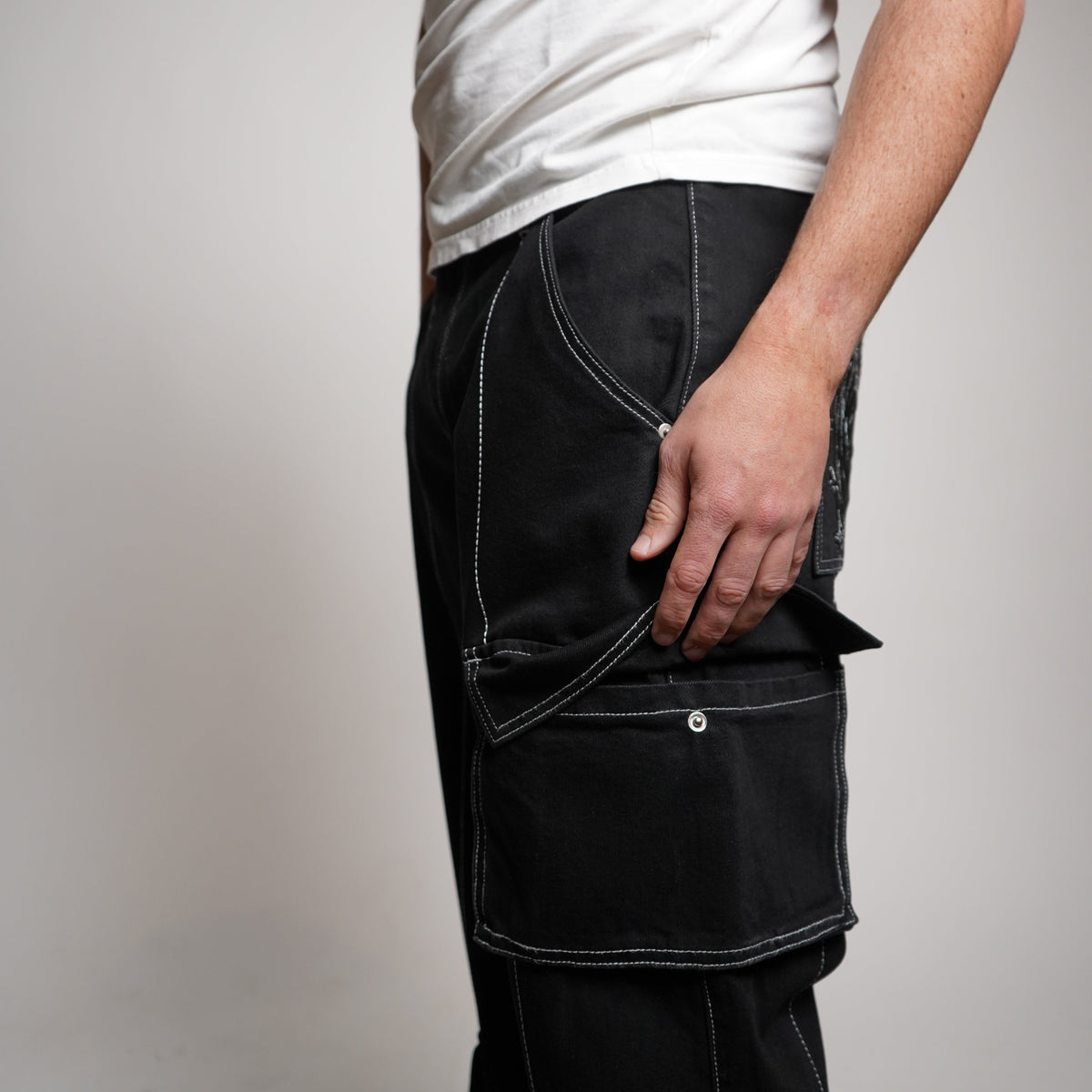 Person holding a black leather jacket against a plain background