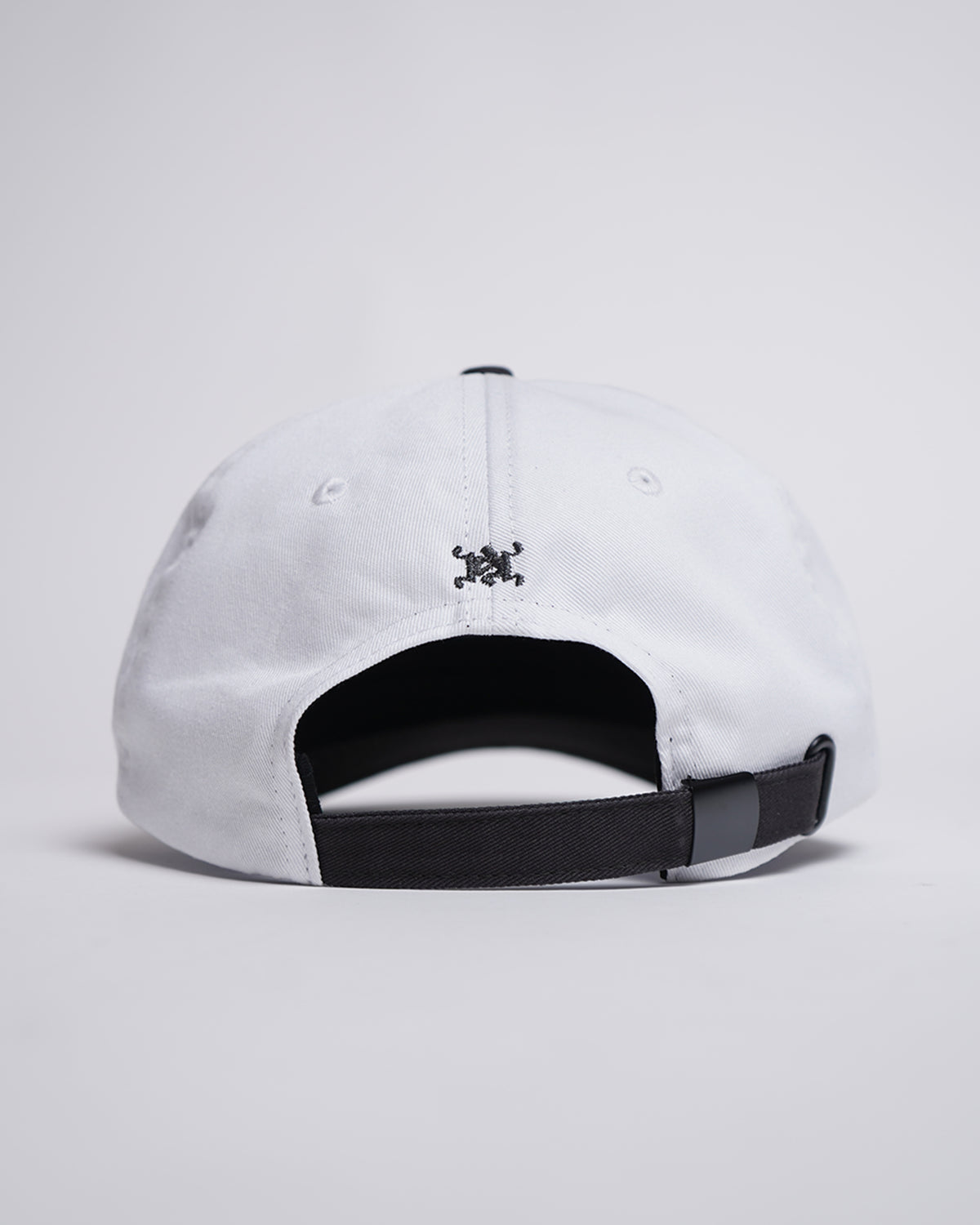 Back view of the white Fire Fist Hat showing black adjustable strap and small embroidered monogram