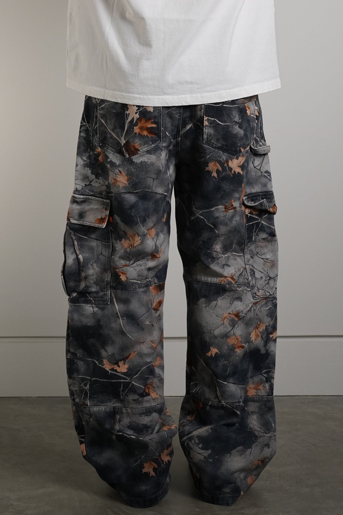 Hidden Inventory Pants in blue denim with orange leaf print, back view in model