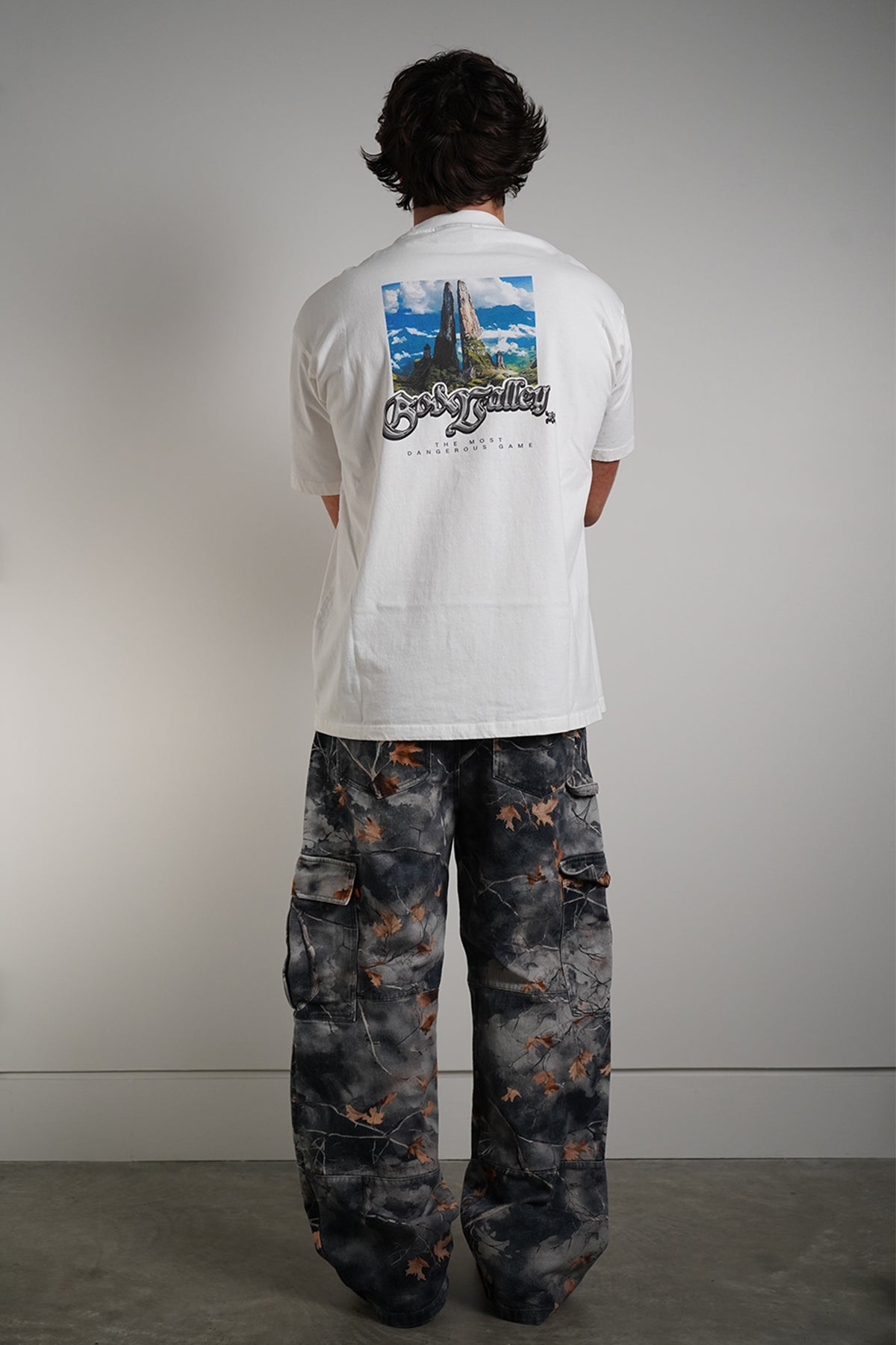 Hidden Inventory Pants in blue denim with orange leaf print, back view in model