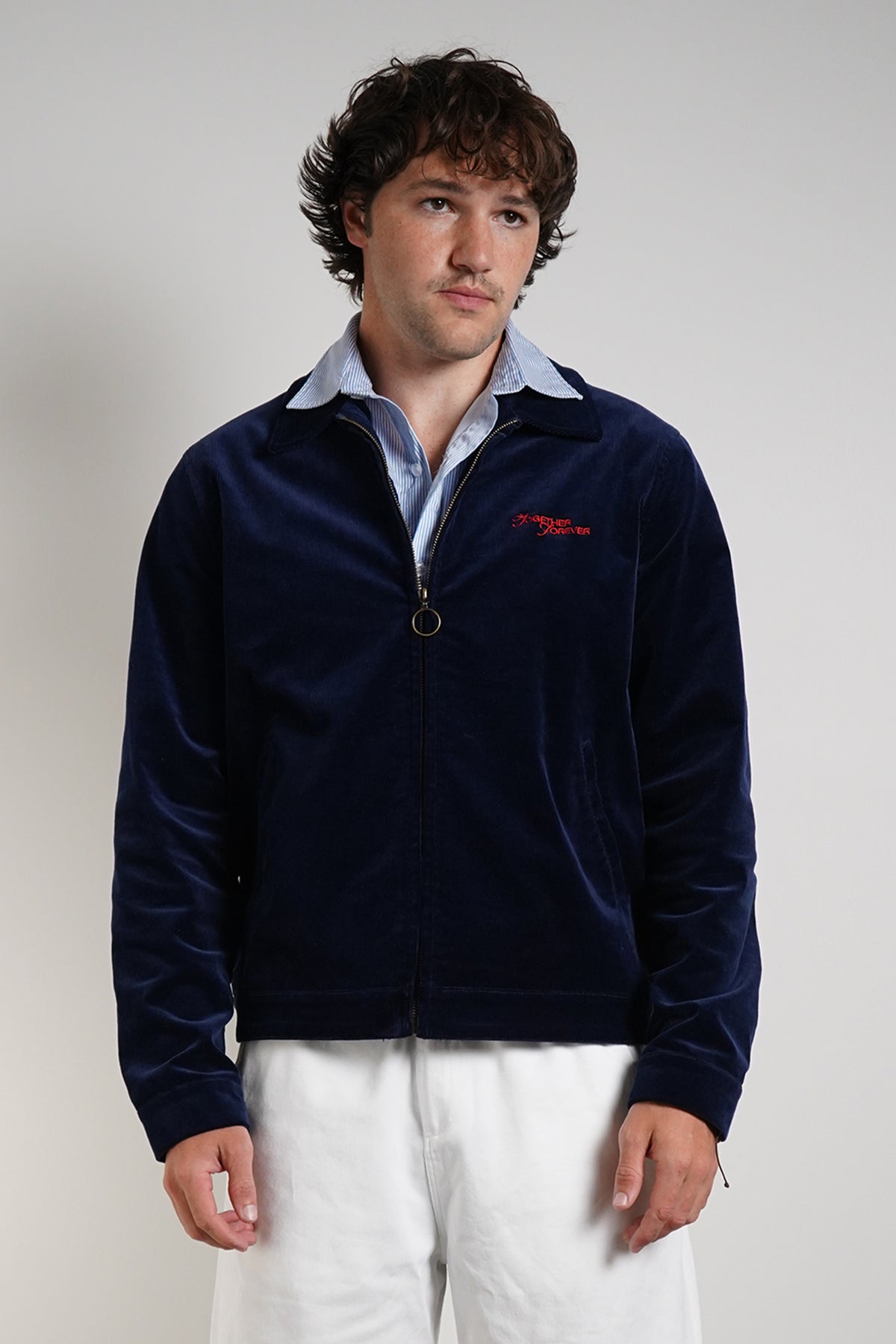 Navy Queen of Curses Jacket with red embroidered logo, front view on model with blue shirt.