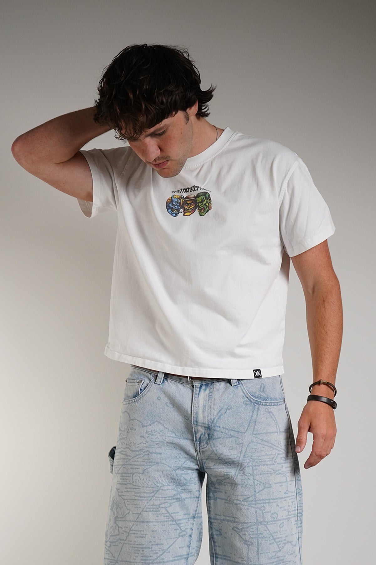 White Monster Trio Tee with three monster faces chest graphic, front view on model