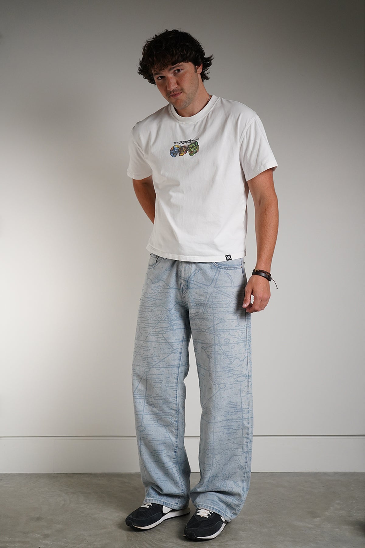 White Monster Trio Tee with three monster faces chest graphic, front view on model