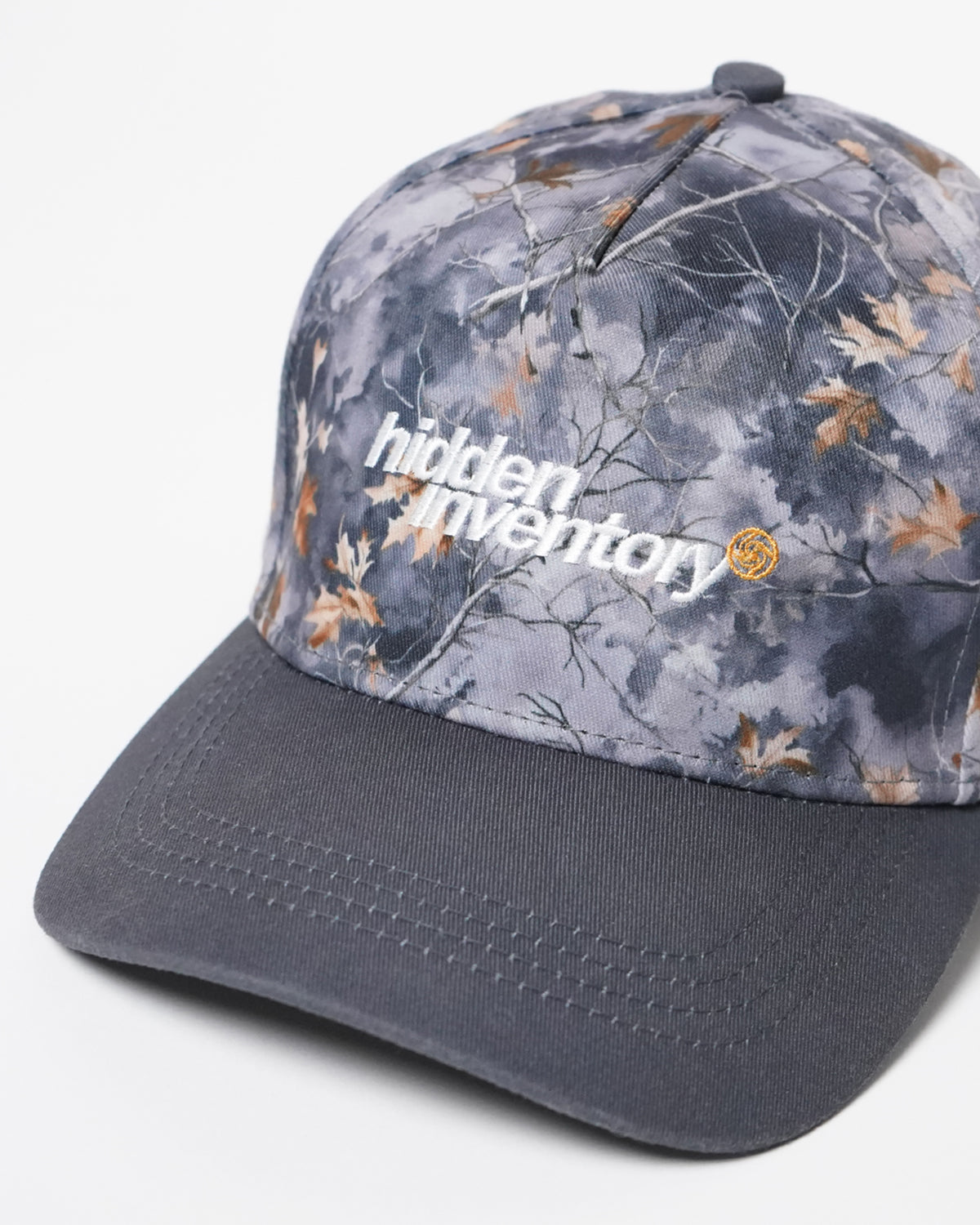Hidden Inventory Hat in gray camo with white logo text, angled front view