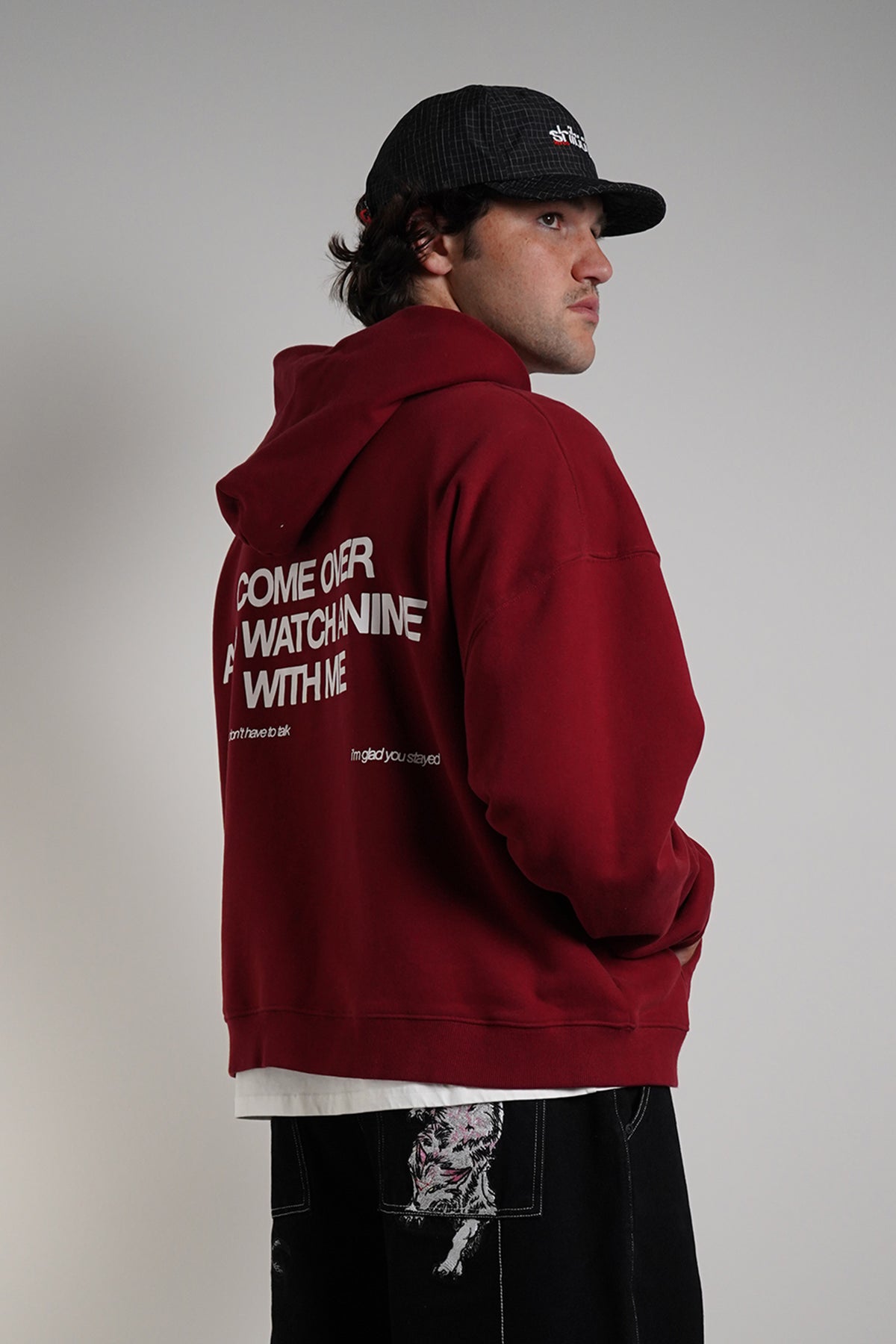 Burgundy Come Over Hoodie with white back graphic, rear view on model with black cap