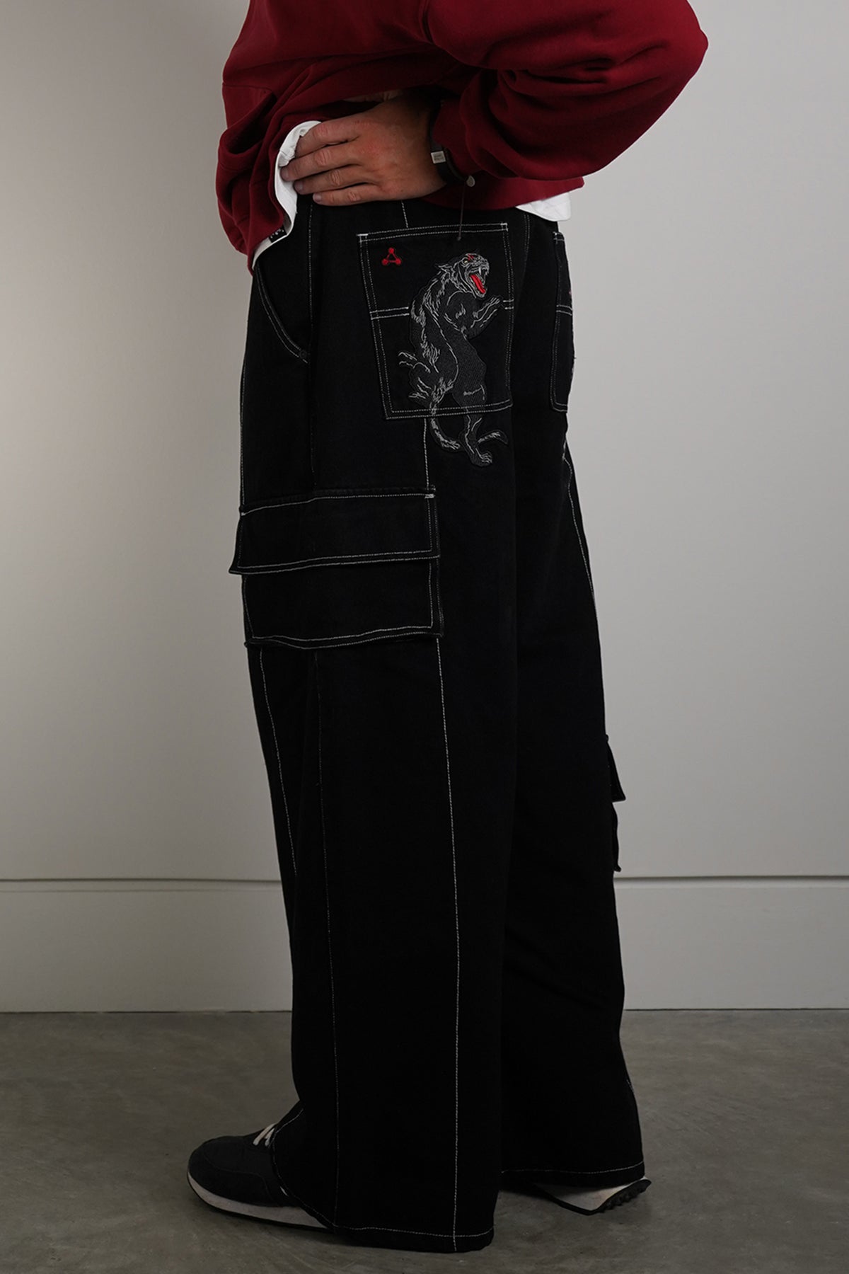Black Divine Dogs Pants with embroidered dog graphics on back pockets, back view on model
