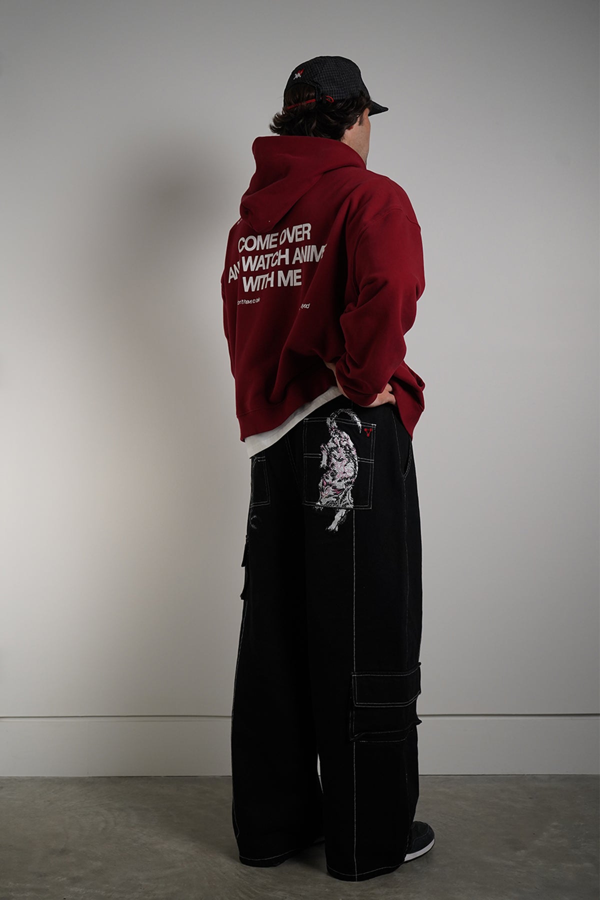 Burgundy Come Over Hoodie with white back graphic, rear view on model with black cap