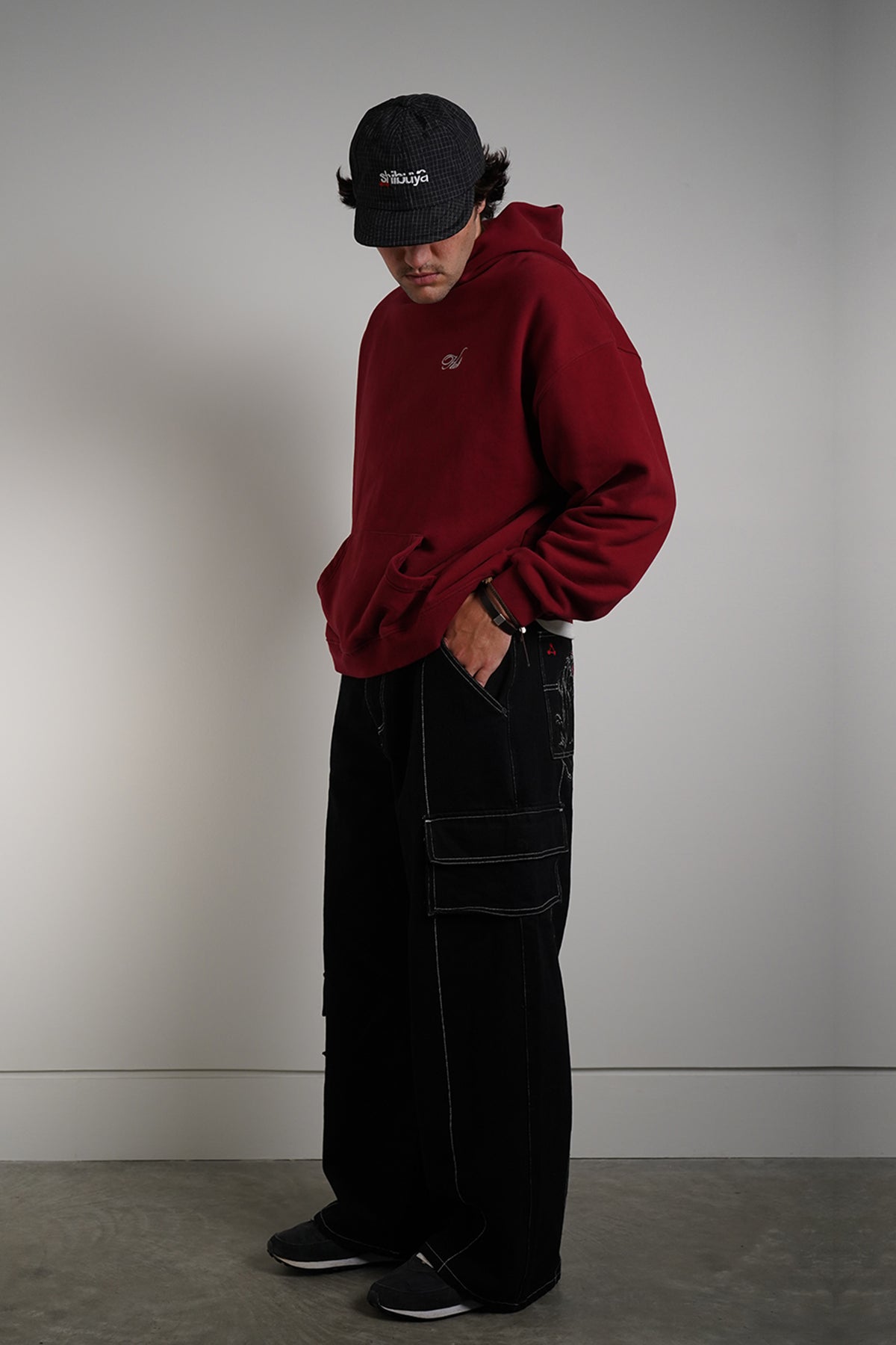Black Divine Dogs Pants with white contrast stitching and cargo pockets, side view on model