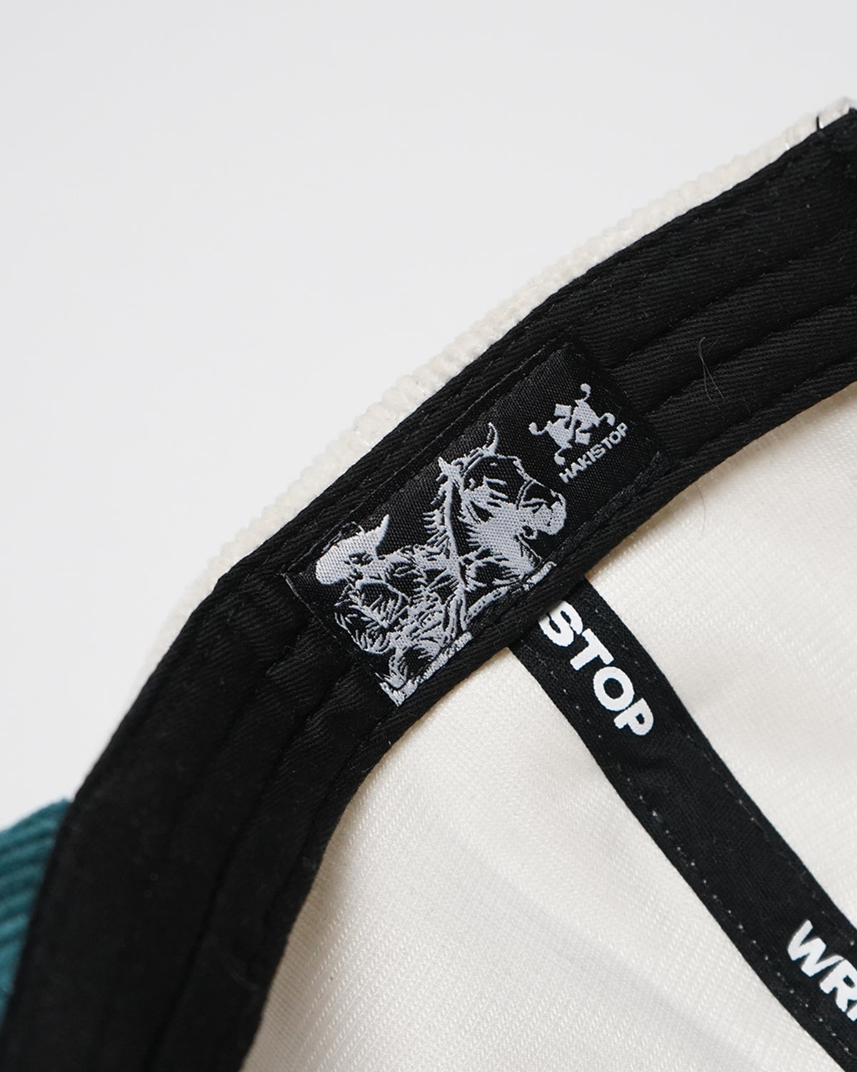 Inside of the Easy Come Easy Go Hat in Tennis Green: a black woven label with a horse-and-rider illustration and the brand logo, stitched to the black sweatband, with logo taping across the cream lining