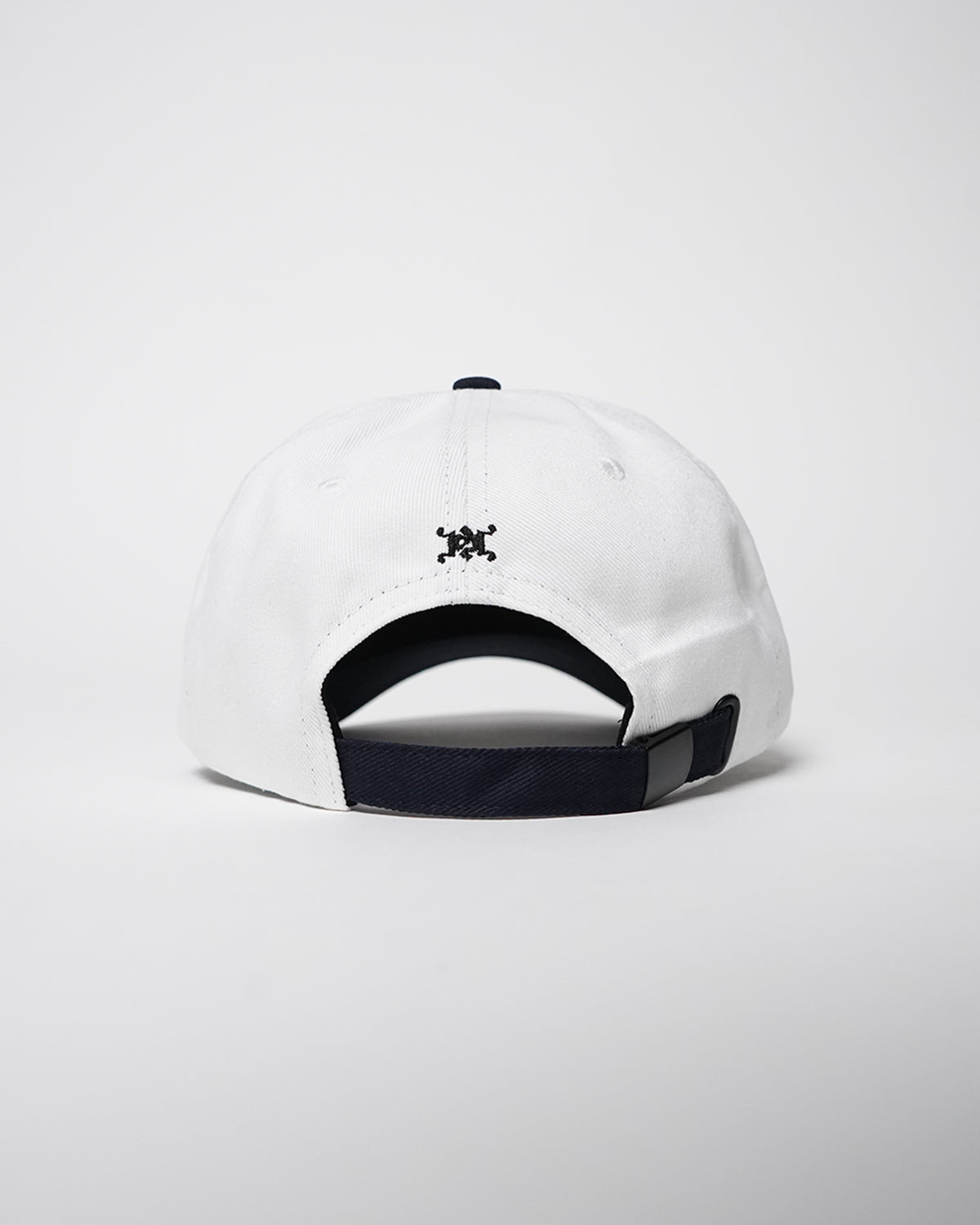 Back view of the white Superrrr Hat showing navy adjustable strap and small black embroidered logo