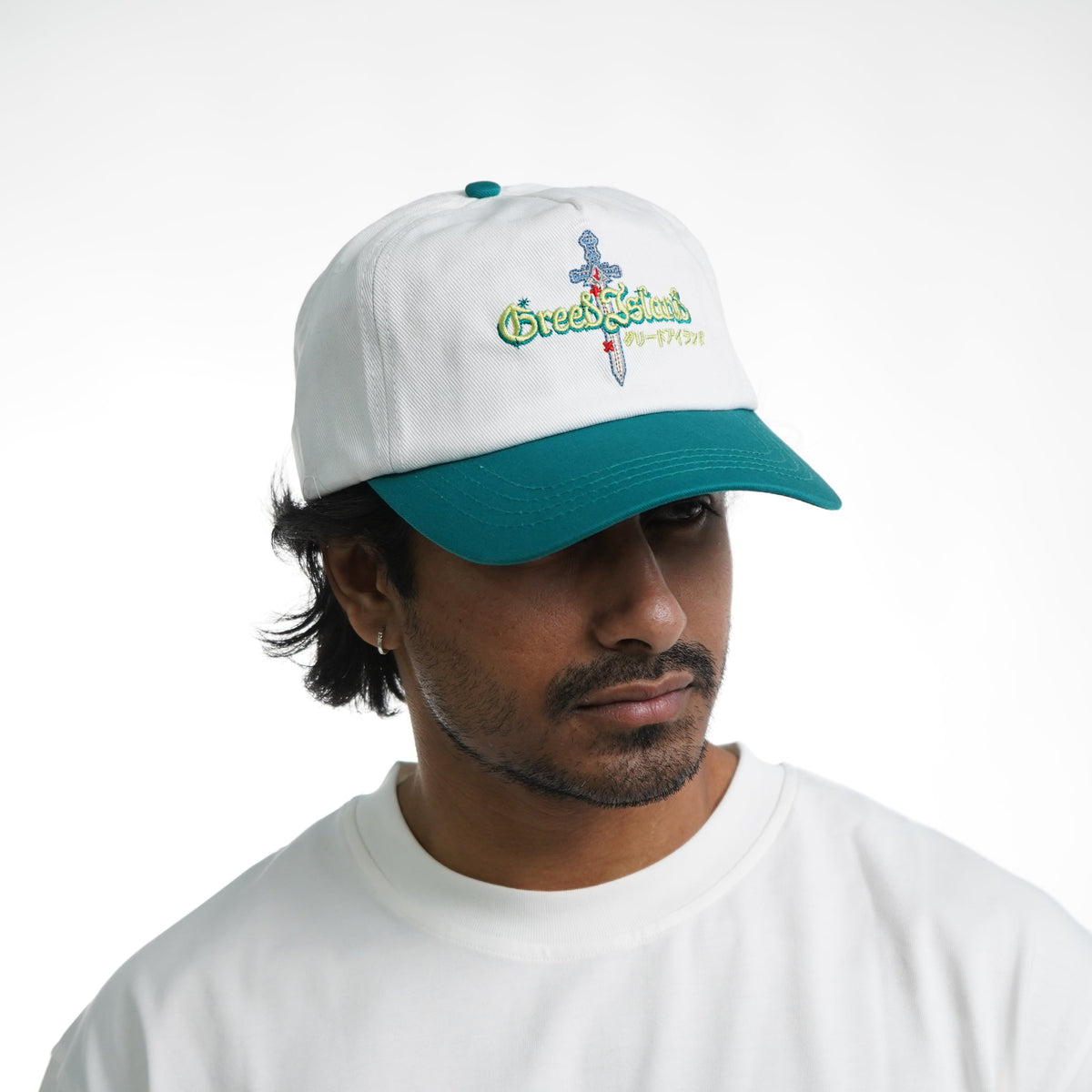 Person wearing a white cap with teal brim and a white t-shirt with colorful graphic design on a white background