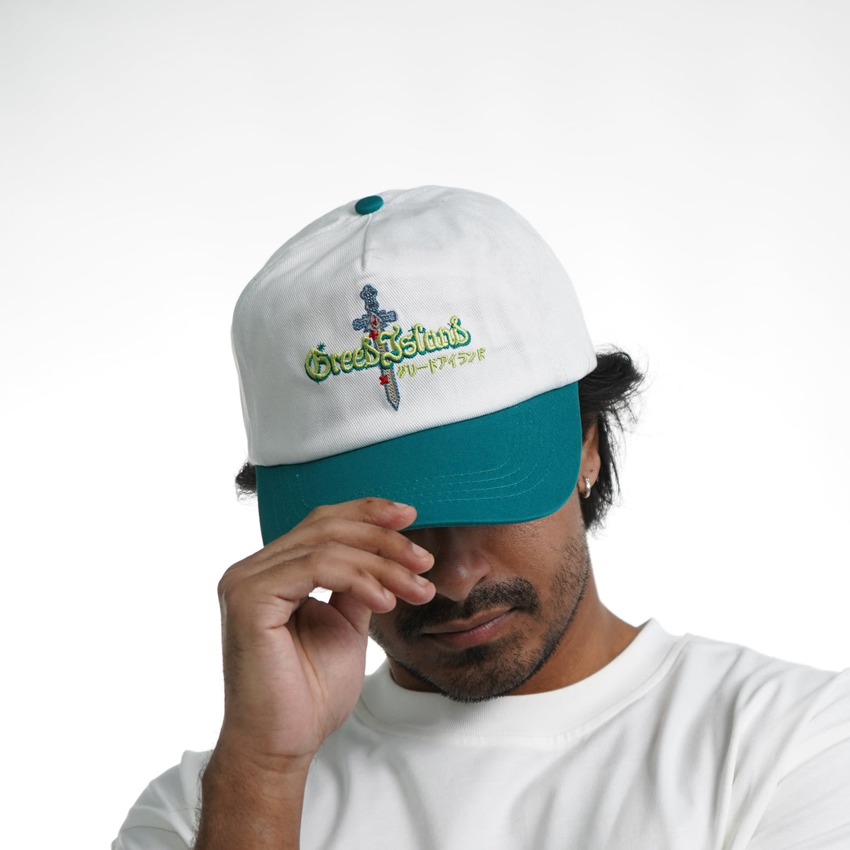 Person wearing a white cap and t-shirt with logos on a white background