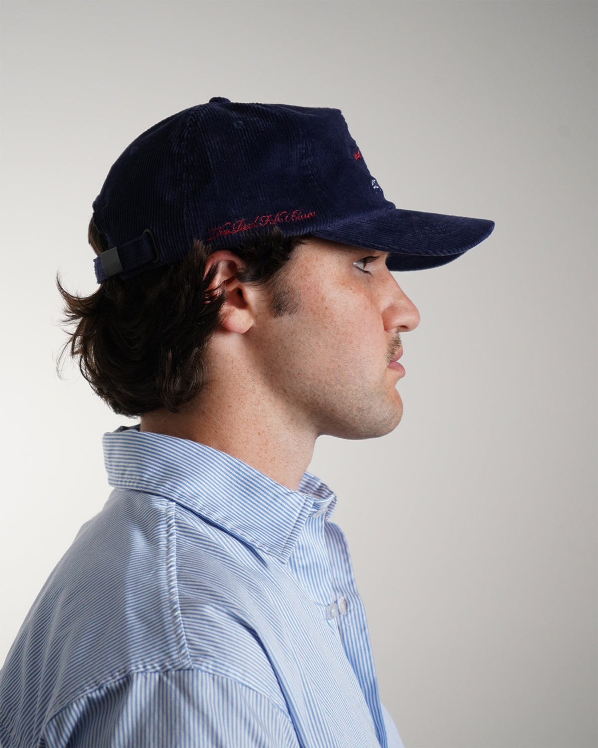Easy Come Easy Go Hat in Midnight Blue corduroy with red script text, side view.
