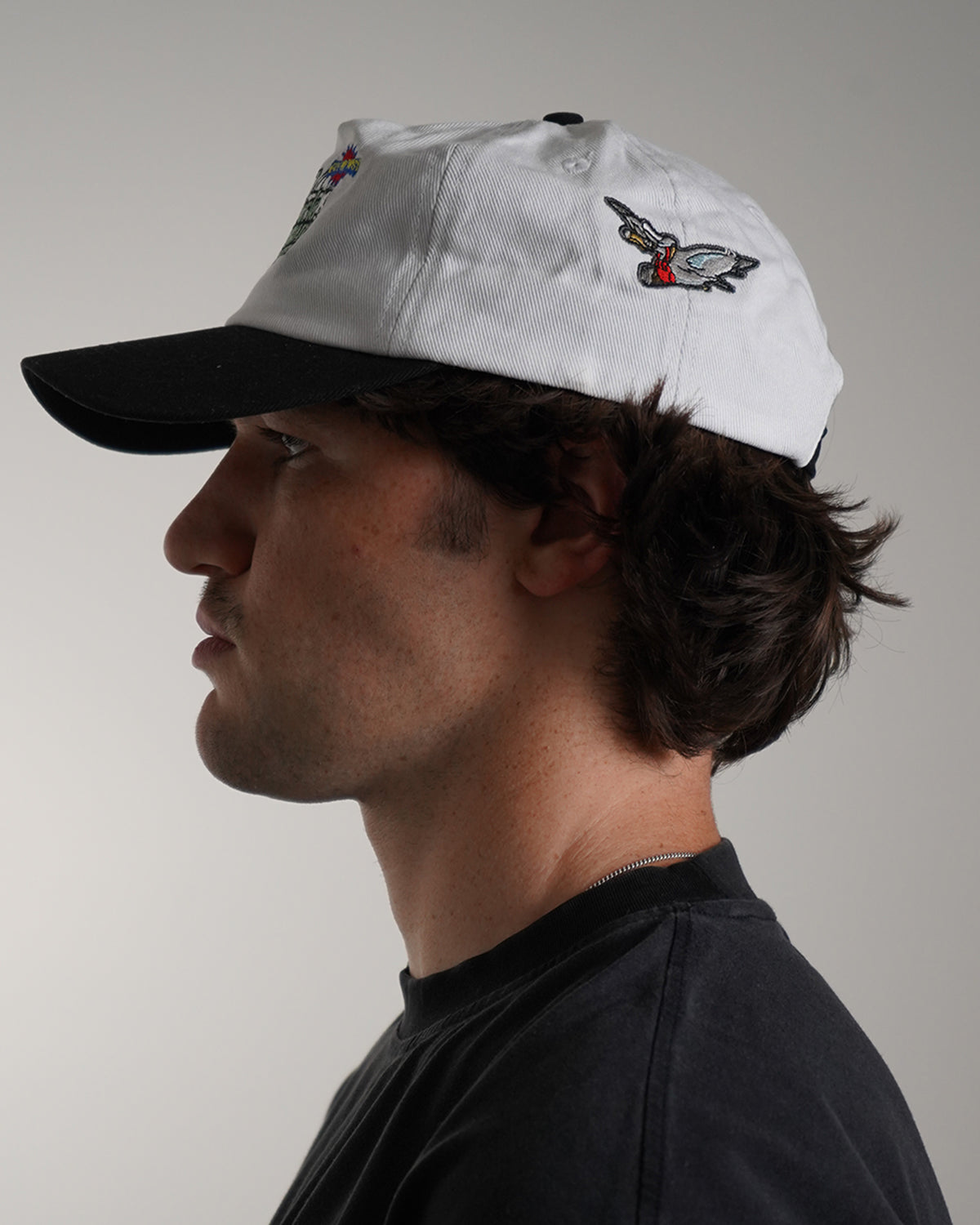 White Big News! Hat with green embroidered logo, side view on model 