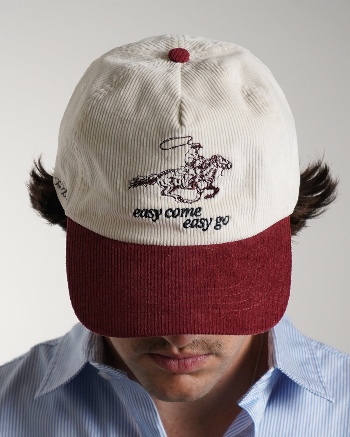 Easy Come Easy Go Hat in cream and burgundy with cowboy graphic, front view on model