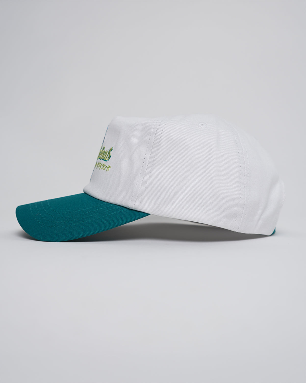 White and teal Greed Island Hat with embroidered logo, side angle view