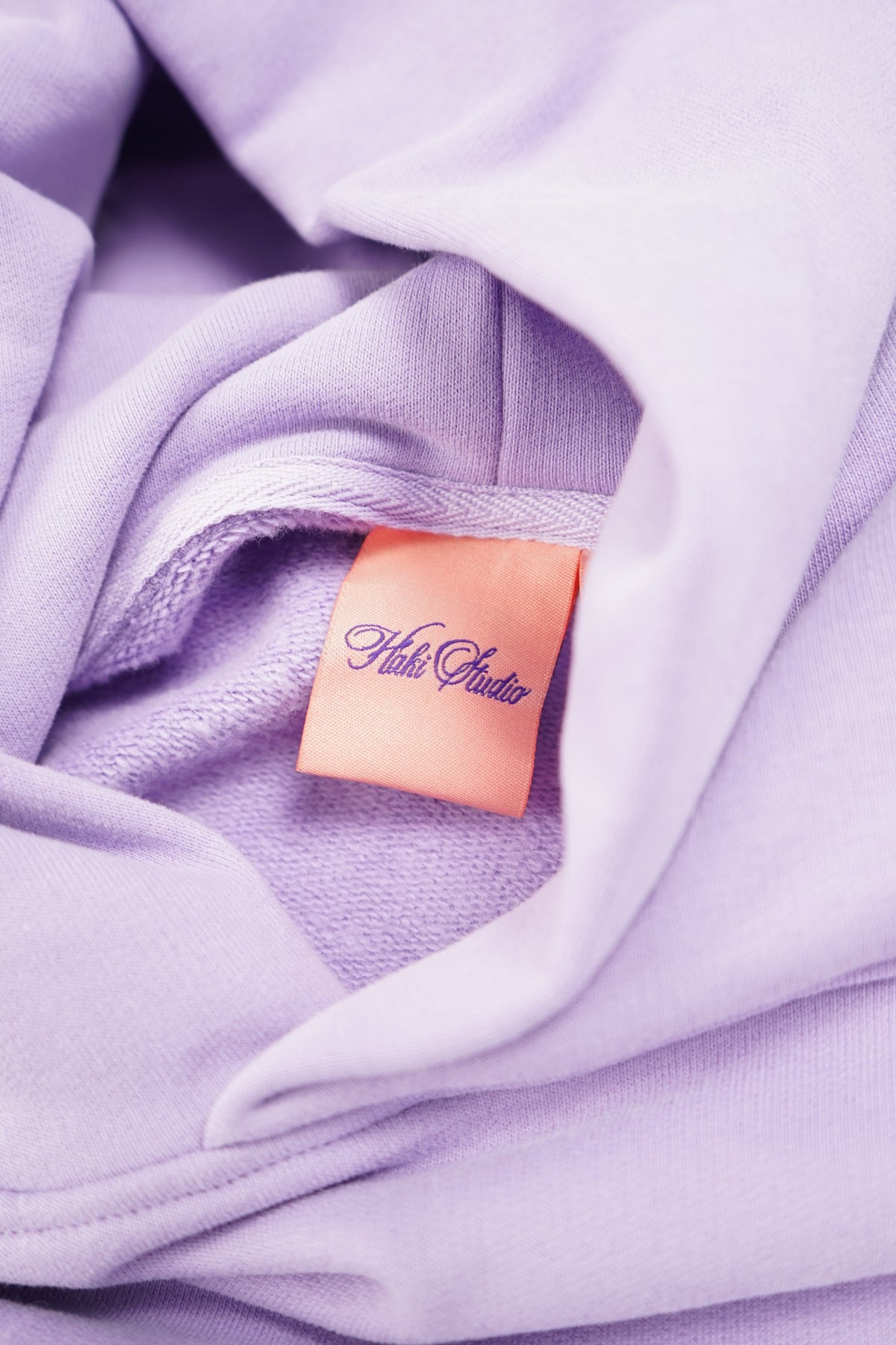 Close-up of a lavender fabric with a brand label.