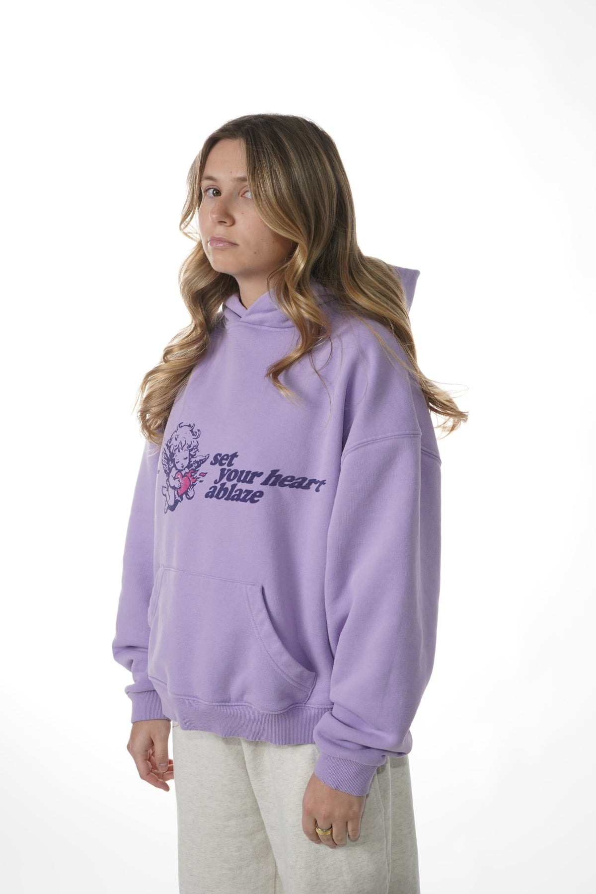 Person wearing a purple hoodie with text and graphics on a white background