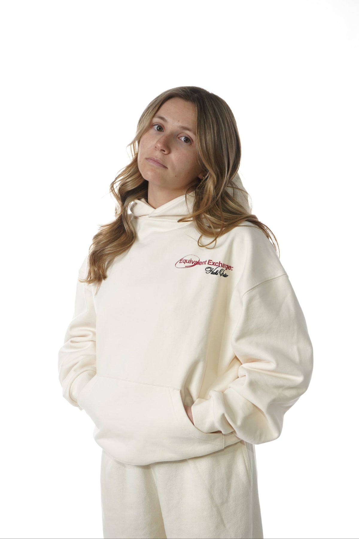 Person wearing a white hooded outfit with a logo on a white background