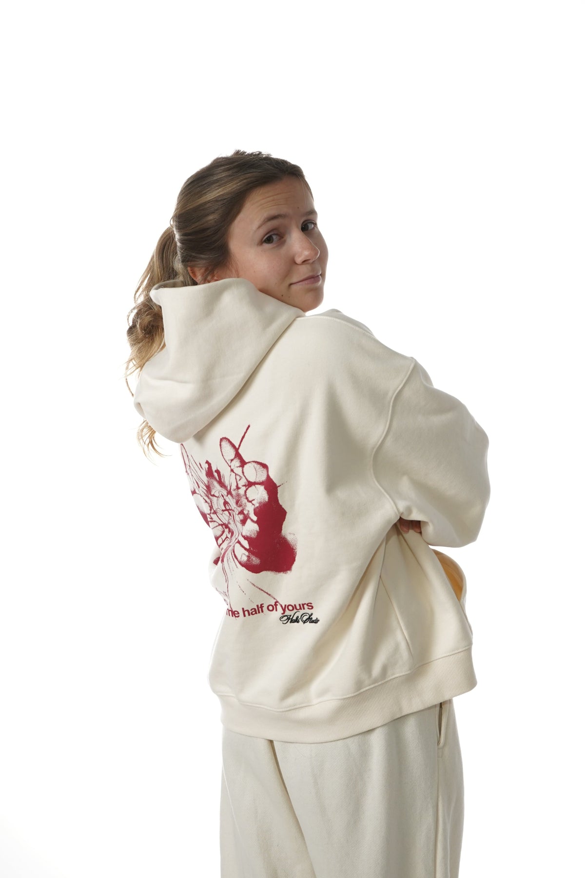 Person wearing a white hoodie with a red design on a white background