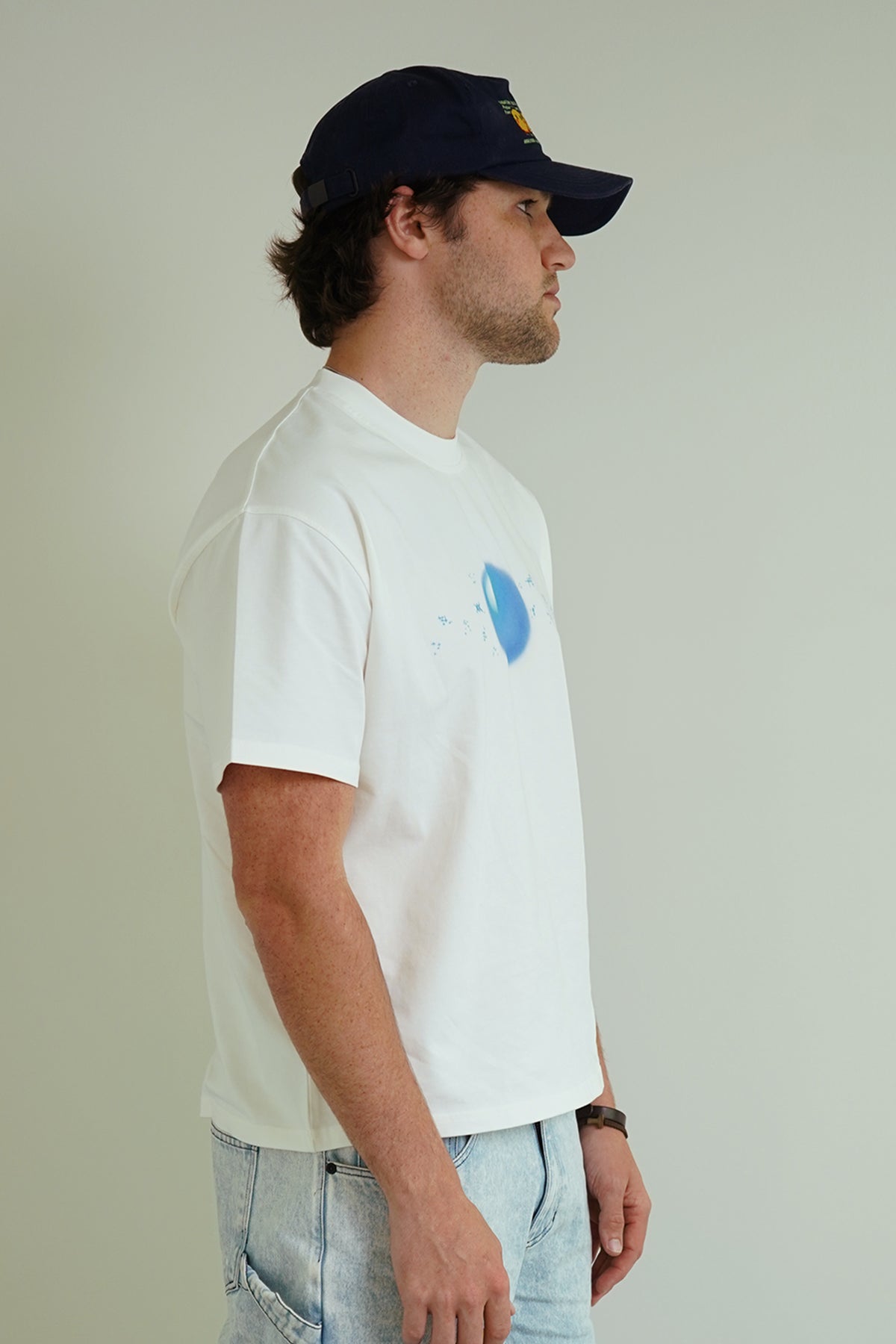 White Dragonball 40th Anniversary Tee with blue sphere graphic, side view on model