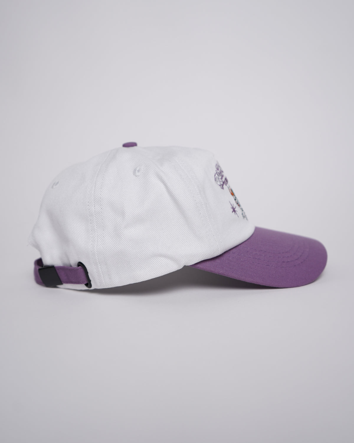 White and purple Guardian Deity Hat with embroidered graphic, angled side view.