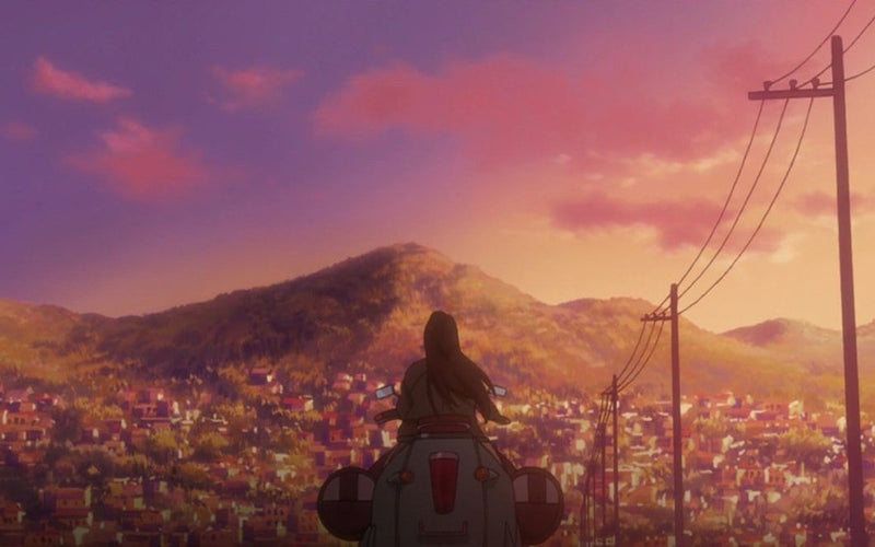 A frame from Michiko & Hatchin: Michiko, seen from behind on her scooter, looks out at a hillside covered in houses under a pink and orange sunset, with power lines running along the road.